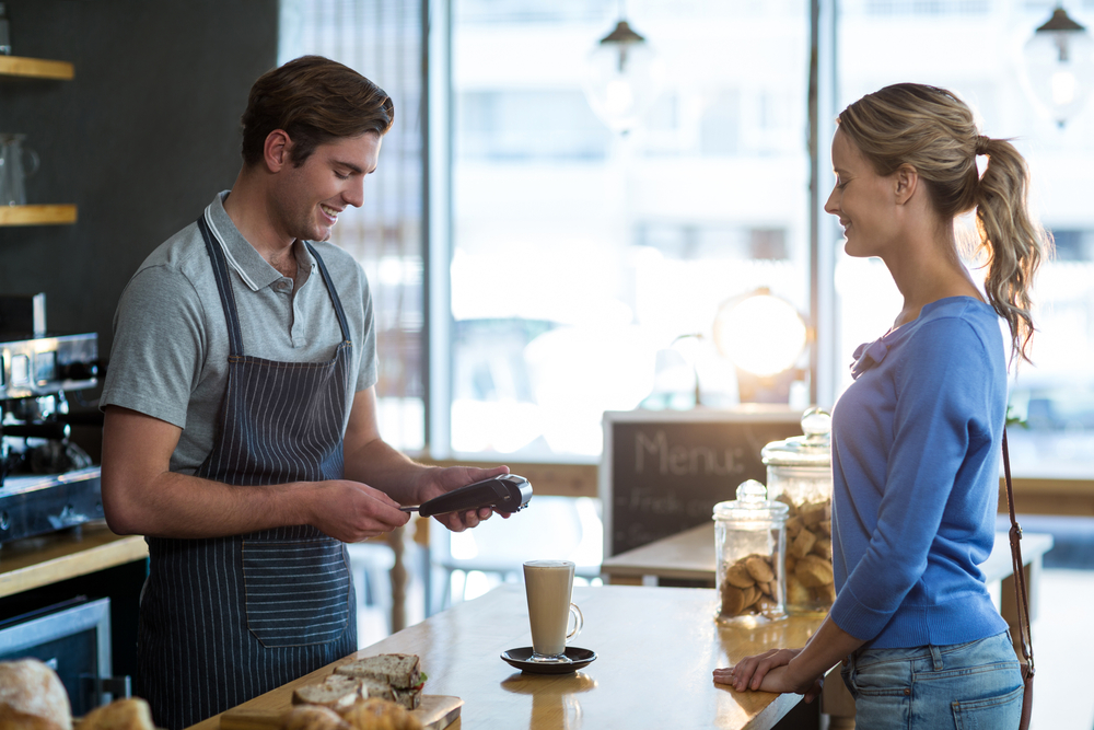 cashier accepting credit card with wireless credit card terminal.